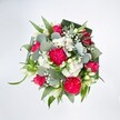 A top-down view of a full, rounded bouquet shows a joyful explosion of hot pink and white blooms set crisply against a brilliant white background, every colour and texture allowed to shine. At the heart of the design, large, ruffled hot pink carnations create a plush, almost cloudlike centre, their many petals folded and layered to give a rich, velvety texture. Nestled among them are deep pink and fuchsia roses, some fully unfurled into classic spirals, others still in tighter buds that promise to open over the next few days, suggesting movement and life. Around these bolder flowers, clusters of petite white spray chrysanthemums and daisy-like blossoms form soft cushions of light, joined by airy sprigs of white baby's breath that float like tiny stars between the larger stems. A few slender white buds, resembling alstroemeria or lily-like flowers, rise gracefully from the mix, adding an elegant vertical line and a gentle sense of purity. The blooms are cradled by an abundance of fresh greenery: rounded, silvery-green eucalyptus leaves provide cool, waxy discs of colour, while long, bright green blades and darker, folded aspidistra leaves create a structured collar around the base, framing the bouquet like a living wreath. The lighting feels clean and natural, as though the arrangement were laid out on a bright table in a Greenford studio, ready to be delivered to a nearby home off Ruislip Road or near Perivale Park. The overall mood is festive yet tender, a bouquet that would effortlessly suit a birthday, a thank-you, or a joyful congratulations delivery anywhere across Greenford.